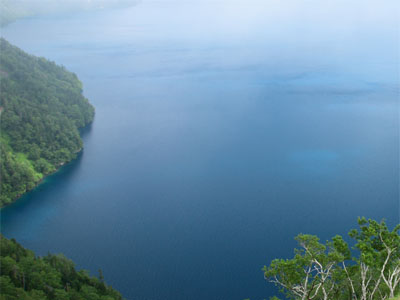a lake of tranquil blue water reflecting tranquil blue sky